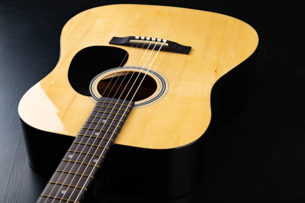 istock Classical guitar on a dark wooden table. Musical instrument stringed. Black background. 1149610468