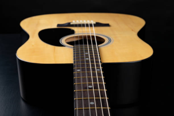 istock Classical guitar on a dark wooden table. Musical instrument stringed. Black background. 1149610523