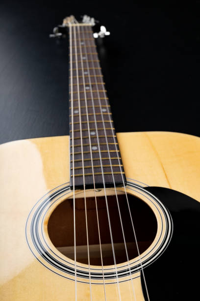 istock Classical guitar on a dark wooden table. Musical instrument stringed. Black background. 1149611097