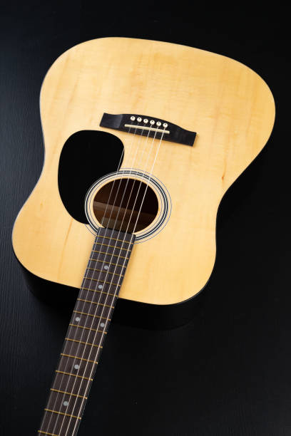 istock Classical guitar on a dark wooden table. Musical instrument stringed. Black background. 1149611286
