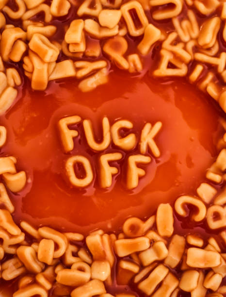 The words 'Fuck Off' spelt out using alphabet pasta shapes stock photo