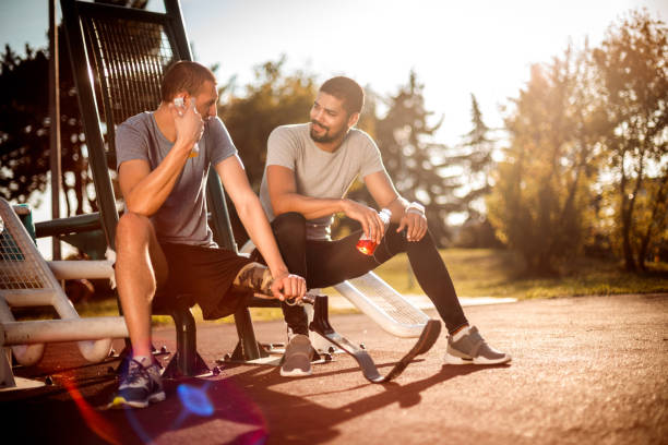 istock Friends having a break during a workout session in a city park gym 1149616534