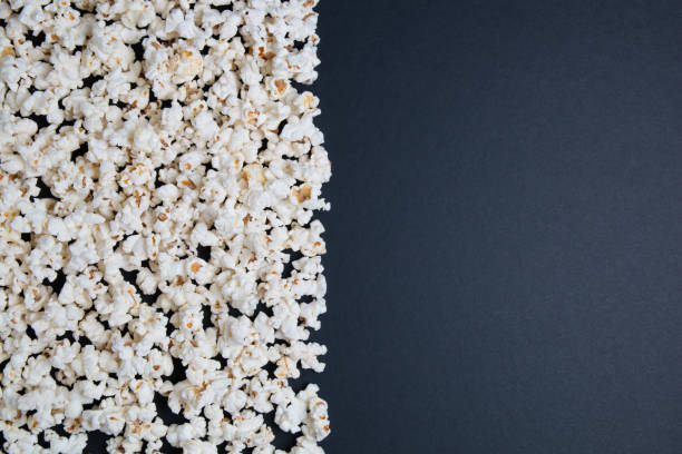 istock Popcorn in a glass bowl on a black background. Top view with copy space. 1149621270