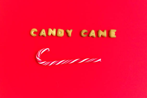 istock Letter Word candy cane. Alphabet Cookie Cracker on red  paper texture and Red candy canes. Sweets concept Top view, copy space, flat lay. 1149622648