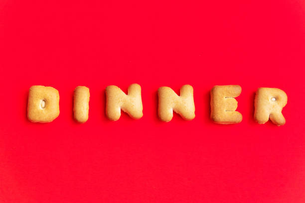 istock The Letter Word Dinner. Alphabet Cookie Cracker on red background paper texture. Red empty backgrounds. Top view, copy space, flat lay. 1149622710
