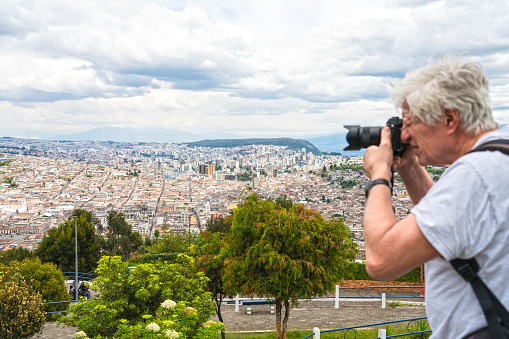 High angle view on cityscape of Quito and senior men photographing the cityscape, Ecuador.