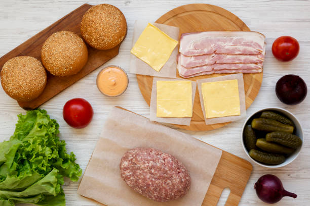 istock Cheeseburger ingredients on a white wooden surface, top view. Overhead, from above, flat lay. Close-up. 1149622856