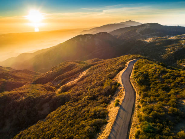 Winding mountain road at sunset in California Aerial view of East Camino Cielo Road along the top of the Santa Ynez Mountains  at sunset , Santa Barbara, California santa barbara california photos stock pictures, royalty-free photos & images