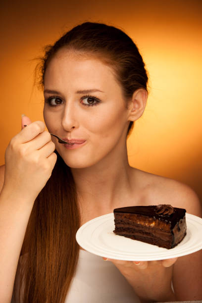 istock chocolate cake - glamorous woman eats dessert 1149626707