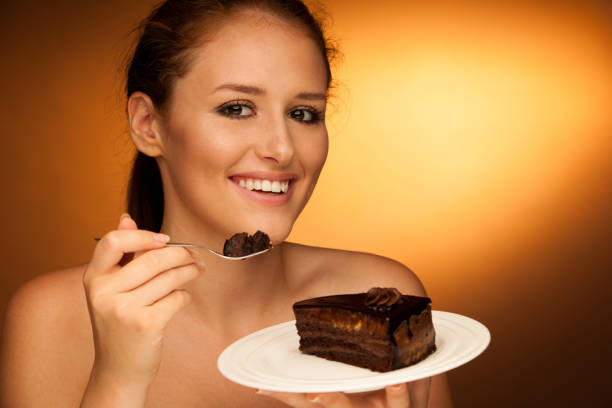 istock chocolate cake - glamorous woman eats dessert 1149626709