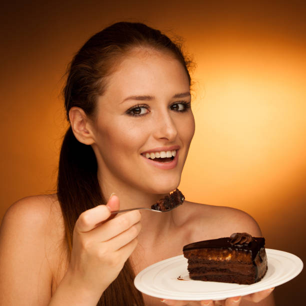 istock chocolate cake - glamorous woman eats dessert 1149626718