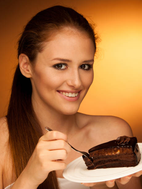 istock chocolate cake - glamorous woman eats dessert 1149626721