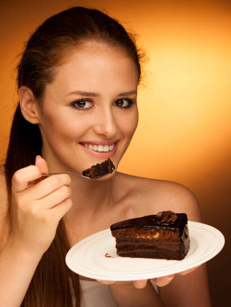 istock chocolate cake - glamorous woman eats dessert 1149626723