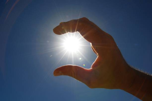 istock One Hand Catching the Sun Stars on a Blue Background 1149630205