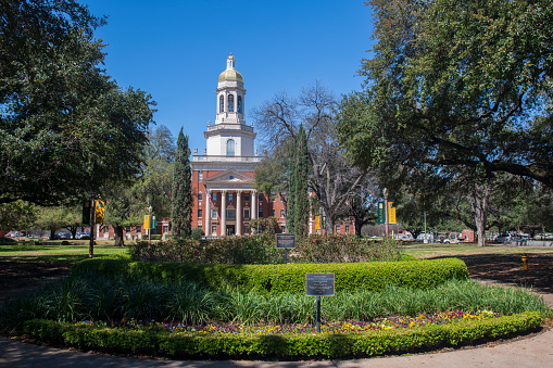 Waco, USA - March 13, 2019. Garden and Pat Neff Hall in the campus of Baylor University, Chartered in 1845, Baylor University is a private Christian university with an enrollment of more than 16,000 students. It is one of the top ranking education institutes in the United States.