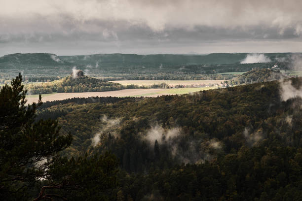 deadpan oscuro brumoso paisaje de la mañana lluviosa con la arena rocosa montanas en la suiza sajona checa en colores otoñales - pravcicka fotografías e imágenes de stock