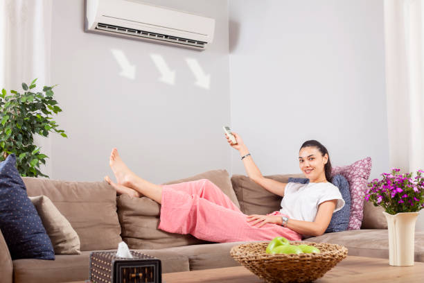 istock woman using remote control of air conditioner 1149637147