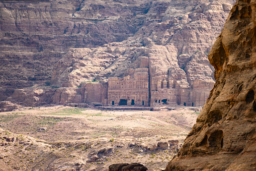 (Selective focus) Stunning view of a huge temple carved in stone framed by rocky mountain in the beautiful Petra site. Petra is a Unesco World heritage site, historical and archaeological city in southern Jordan.