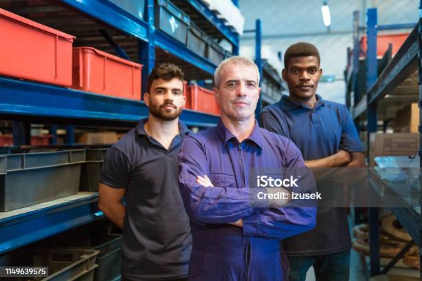 Portrait Of Confident Foreman With Coworkers Stock Photo - Download Image Now - Manufacturing Occupation, Arms Crossed, Blue-collar Worker