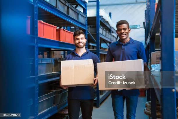 Portrait Of Smiling Warehouse Workers With Boxes Stock Photo - Download Image Now - Cardboard Box, Factory, Men