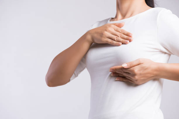 여자 손 회색 배경에 유방암의 징후에 대 한 그녀의 가슴에 덩어리를 확인. 헬스케어 개념. - breast chest the human body human skin 뉴스 사진 이미지