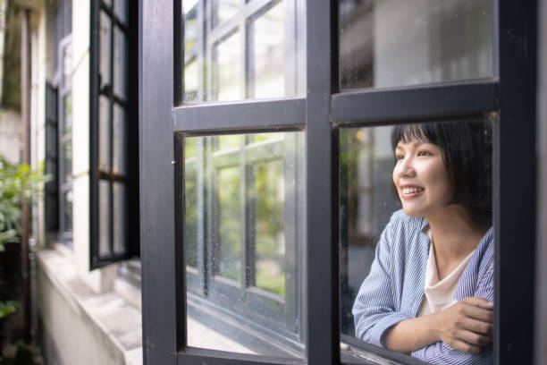 istock Young woman looking through the window 1149651430