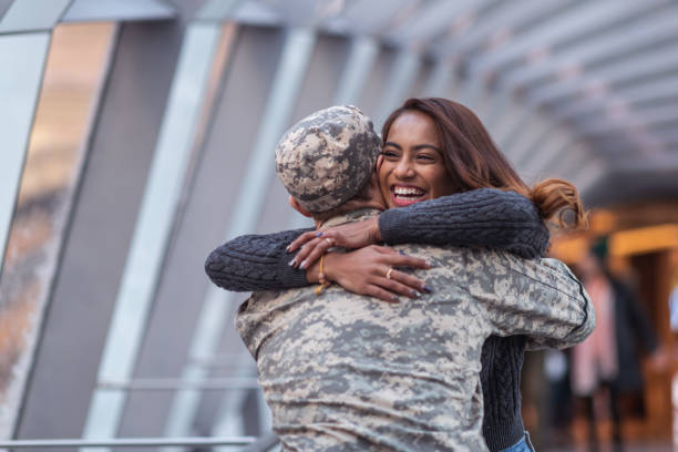 Woman hugging her partner after returning home from service A beautiful woman of Indian descent passionately hugs her partner as she greets him returning from his military service. He is wearing a military uniform. wife stock pictures, royalty-free photos & images