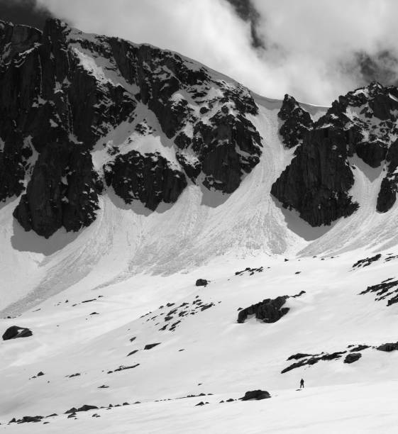 istock Black and white high mountains with snow cornice and avalanche tracks 1149662236