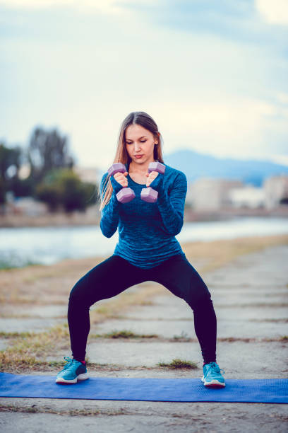 istock Cute Female Athlete Working Out With Weights Outside 1149667076