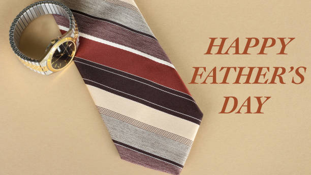 tan and brown tie with a watch on a tan background