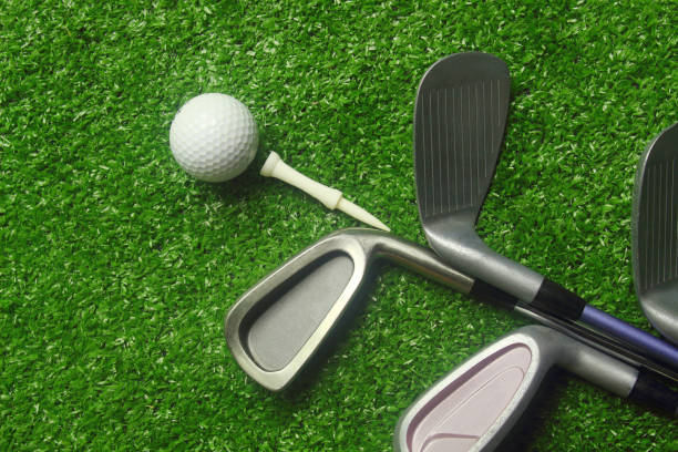 istock Golf balls and golf clubs on green grass 1149689924