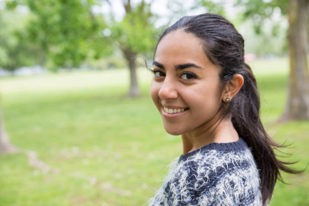 istock Happy pretty young woman posing at camera in park 1149691573