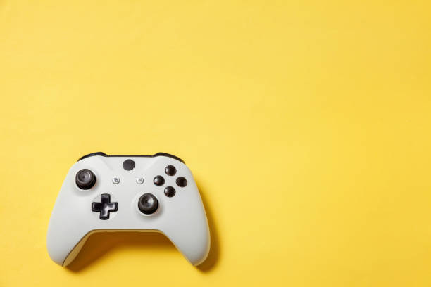 istock White joystick on yellow background. Computer gaming competition videogame control confrontation concept 1149692005