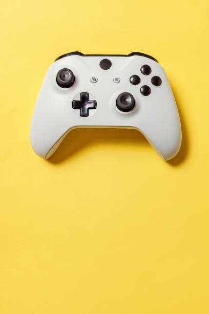 White joystick on yellow background. Computer gaming competition videogame control confrontation concept White joystick gamepad, game console on yellow colourful trendy modern fashion pin-up background. Computer gaming competition videogame control confrontation concept. Cyberspace symbol game controller photos stock pictures, royalty-free photos & images