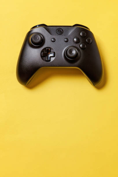 istock Black joystick on yellow background. Computer gaming competition videogame control confrontation concept 1149692592