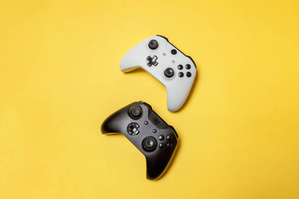 istock White and black two joystick on yellow background. Computer gaming competition videogame control confrontation concept 1149693133