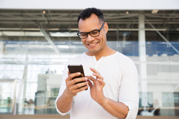 istock Smiling young man texting on smartphone outdoors 1149693441