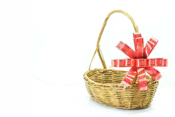 Empty wicker basket with red and gold ribbon isolated on white background