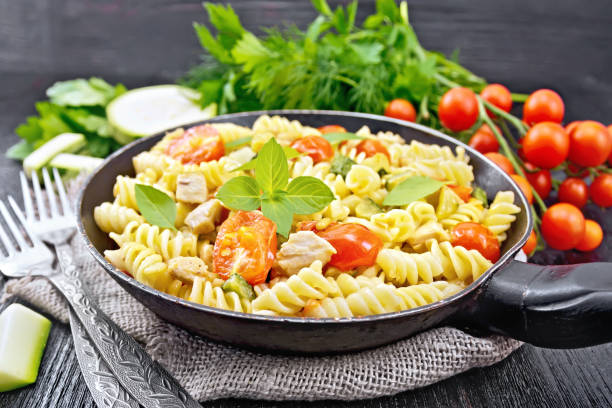 istock Fusilli with chicken and tomatoes in pan on dark board 1149697169