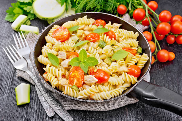 istock Fusilli with chicken and tomatoes in pan on board 1149697172