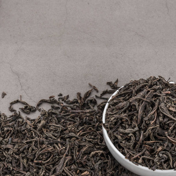 istock Dried tea is poured into a white ceramic cup on a gray textured background. 1149701162