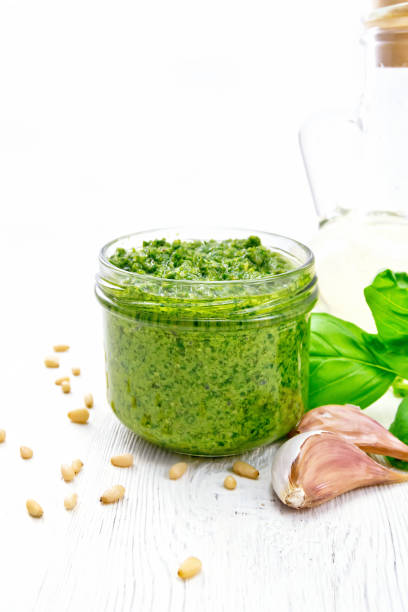 istock Pesto in glass jar on white board 1149701529