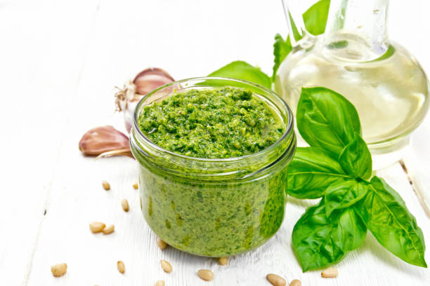 istock Pesto in glass jar on light wooden board 1149701539