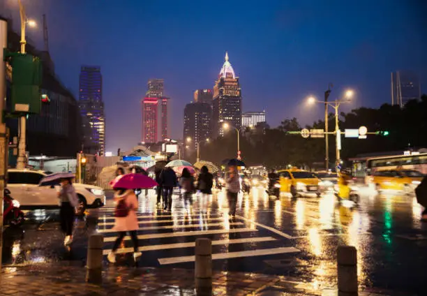 City view of Taipei with rain and people crossing the street at night