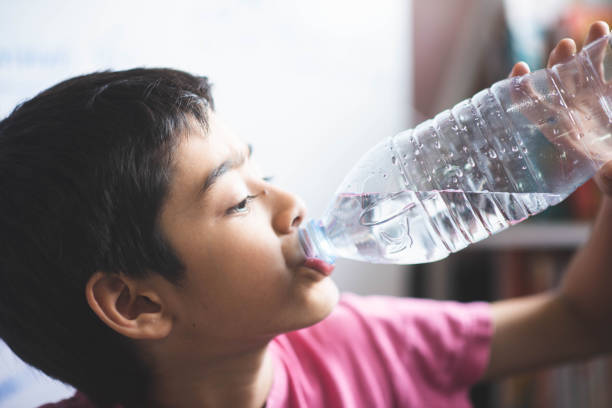 istock Little boy drinking water in the room with happy face 1149702633