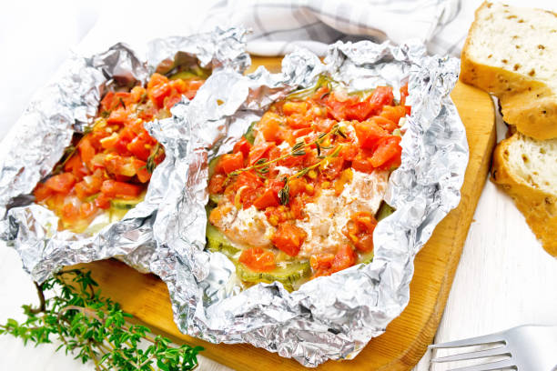 istock Salmon with vegetables in foil on light board 1149702844