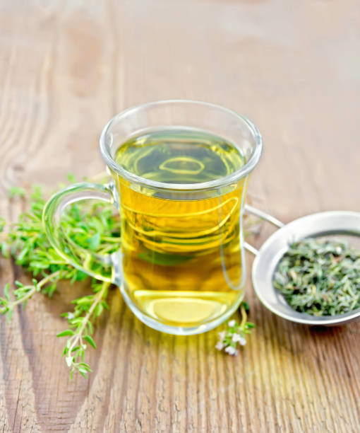 istock Tea of thyme in mug with strainer on old wooden board 1149703557