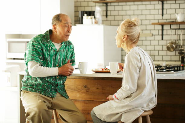 istock Senior couple sitting on a stool in kitchen dining 1149708042