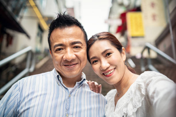 Mature Chinese couple taking a selfie.