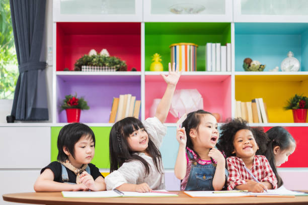 istock Group diversity kids studying at school, rising hands for answer and question in classroom, kids education concept 1149716007